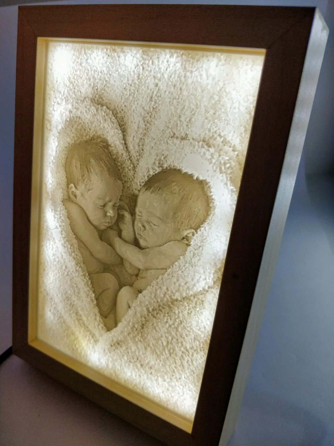 Lithophanie de deux nouveau-nés en forme de cœur, allumée dans un intérieur